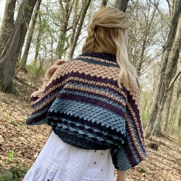 Designer wearing ebb and flow shrug outside in the woods.