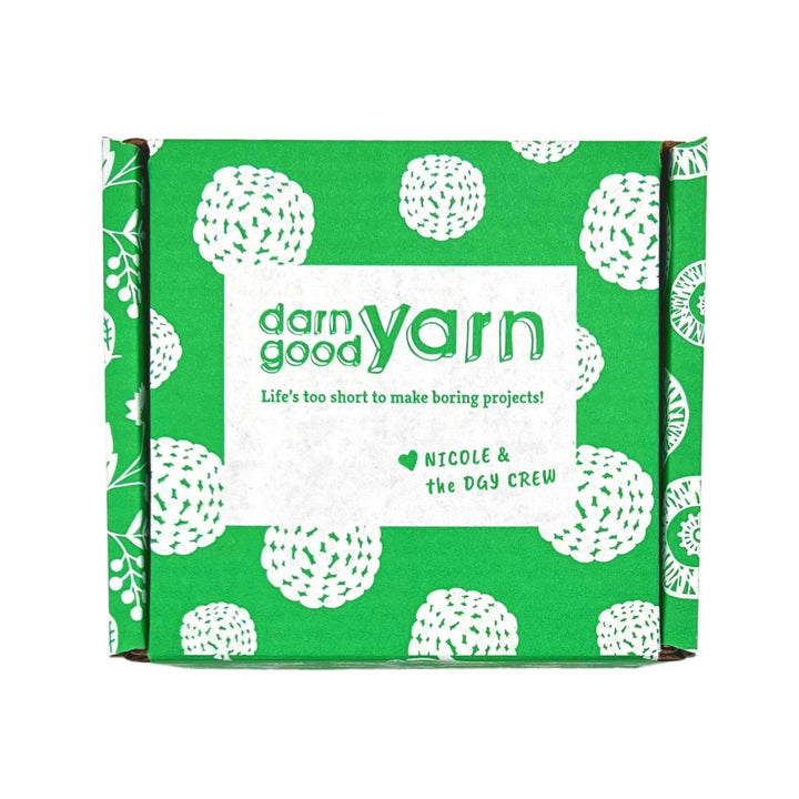 green and white cardboard box in front of a white background.