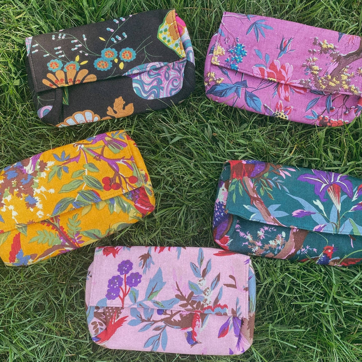 Elegant cotton floral clutches laying on grass.