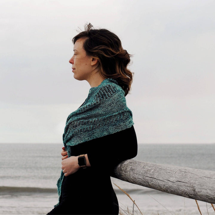 Model wearing emerald bay shawl with the ocean in the background.