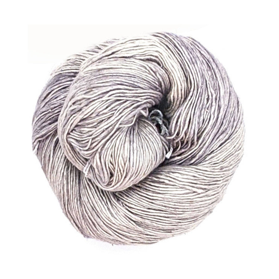 ultimate grey lace weight silk yarn in front of a white background.
