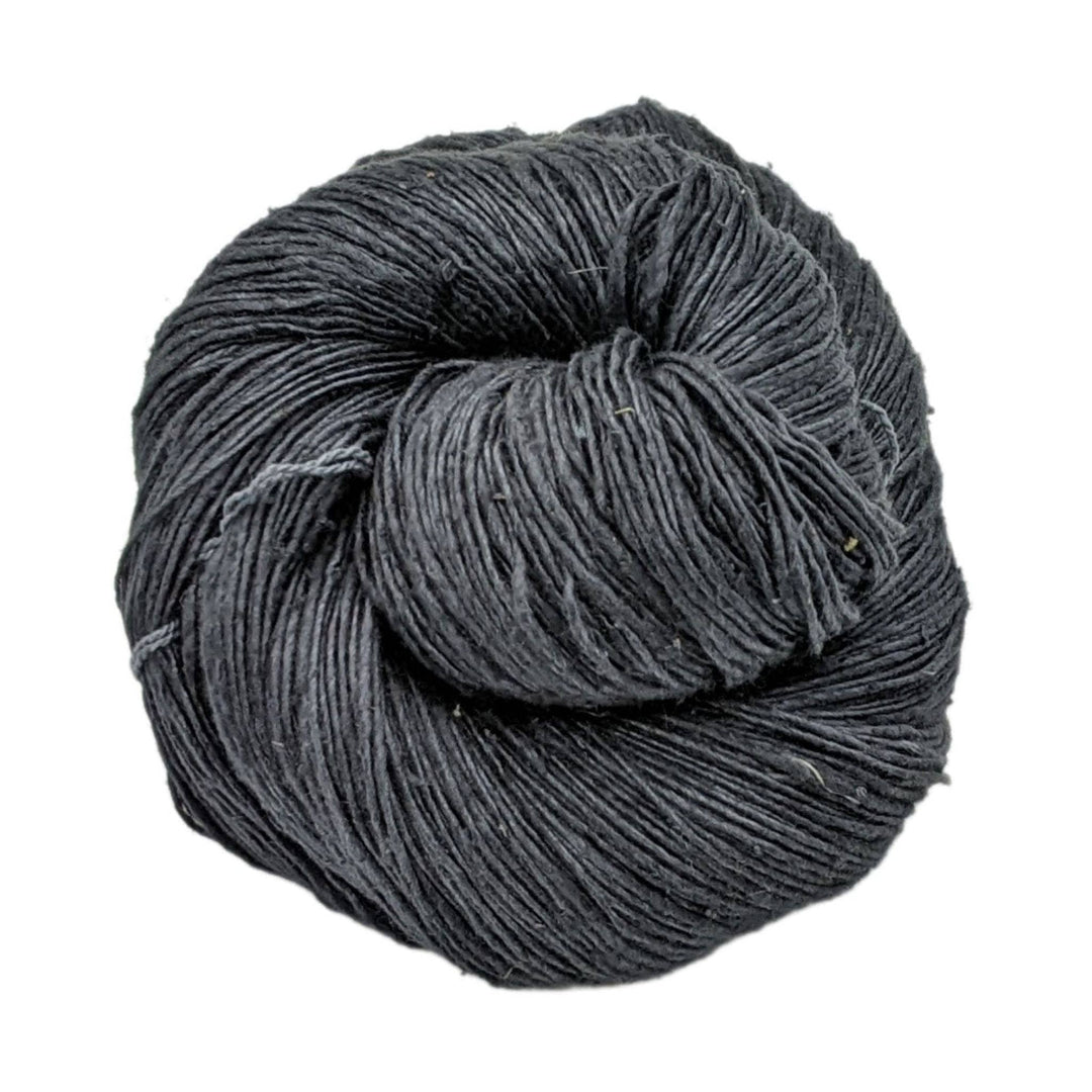 single skein black lace weight silk yarn in front of a white background.