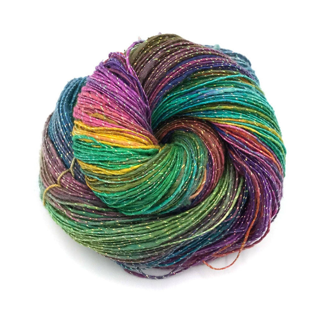 bright rainbow watercolors sparkle lace weight silk yarn in front of a white background. 
