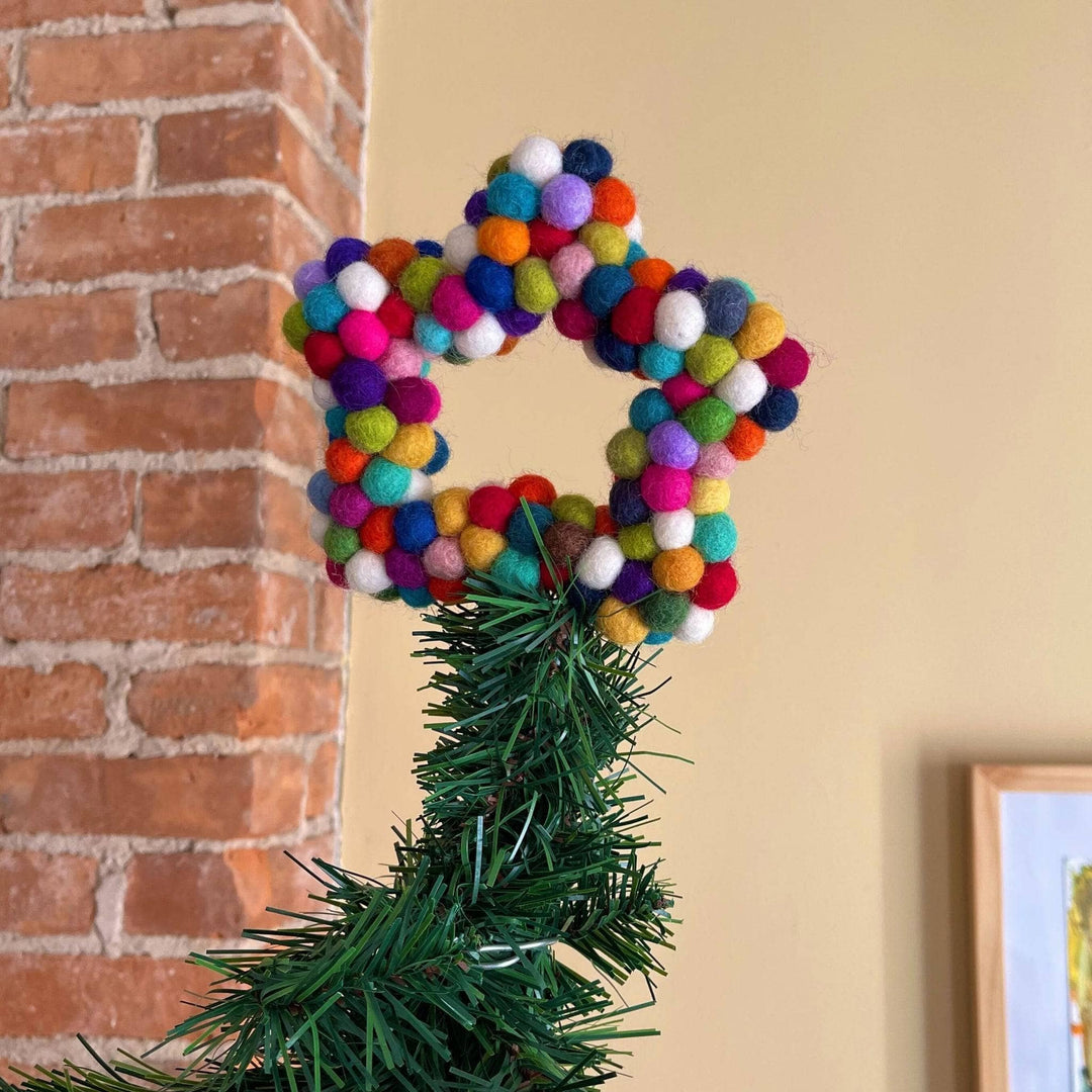 A felt ball star shaped tree topper. The topper is made from rainbow colored felt balls. 