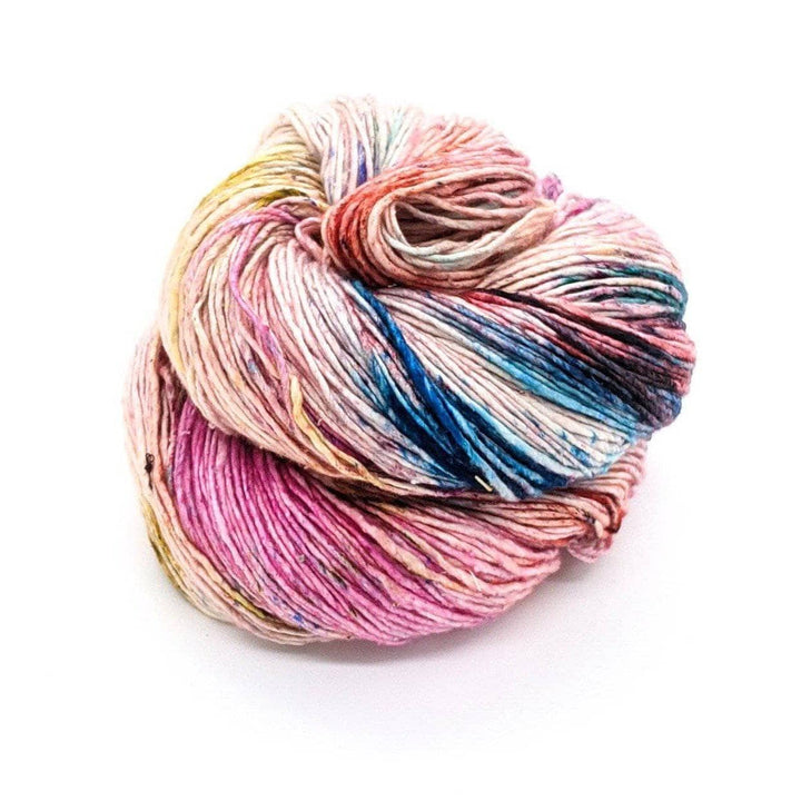 skein of sport weight silk yarn in the colorway confetti (splotches of pink, blue, yellow, orange on undyed yarn) in front of a white background.