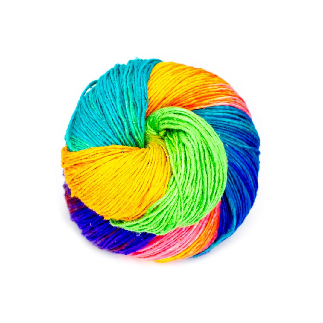 sport weight silk yarn in vibrant multicolor holi colorway in front of a white background.