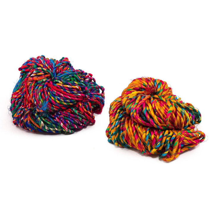 two cakes of multicolored yarn over a white background