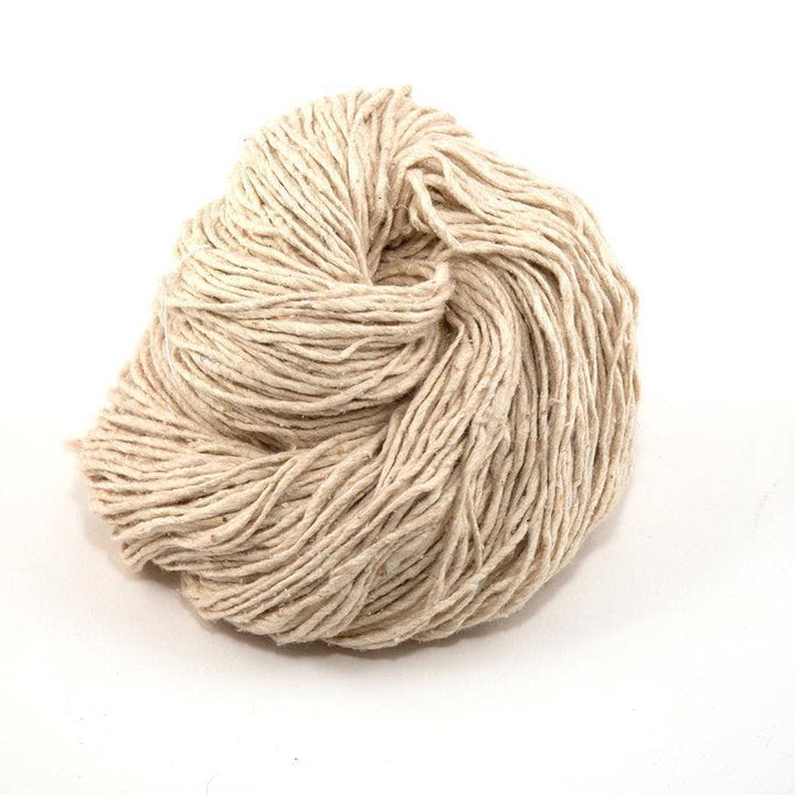 Silk roving worsted weight yarn dandelion poof ( natural, undyed) in front of a white background.