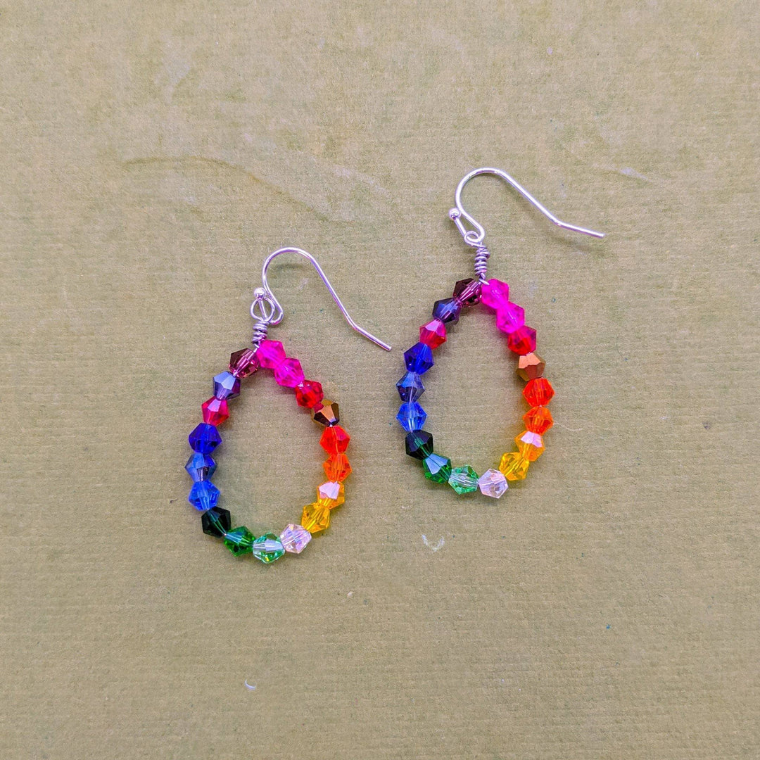 Geometric Rainbow Earrings  on a tan backdrop. 