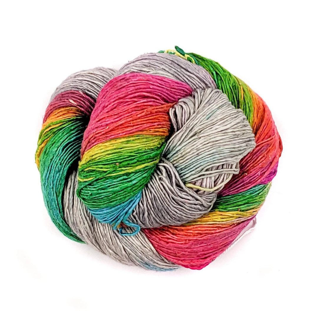 Skein of grey and rainbow lace weight yarn in front of a white background.
