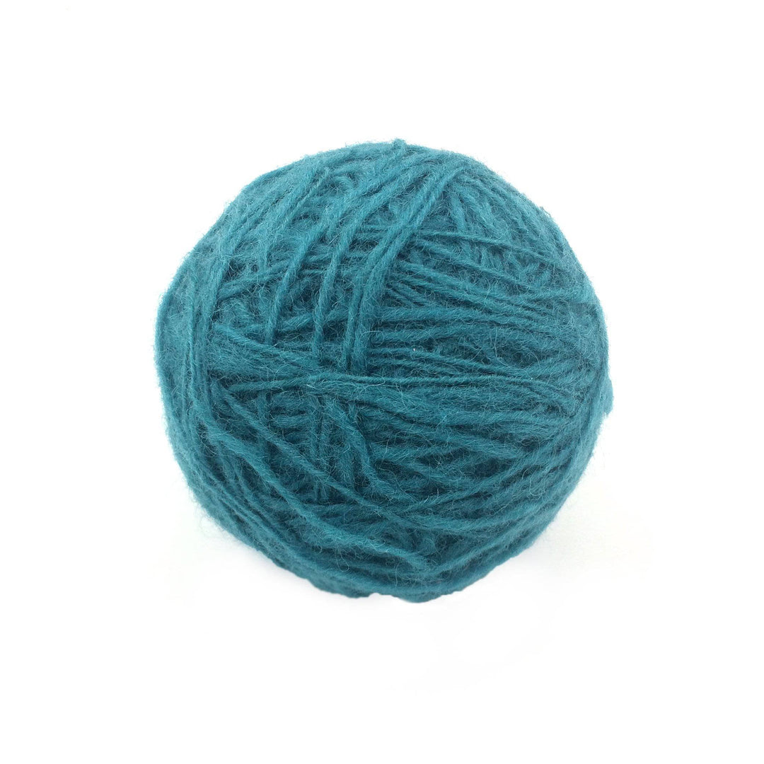 teal yarn cake over a white background