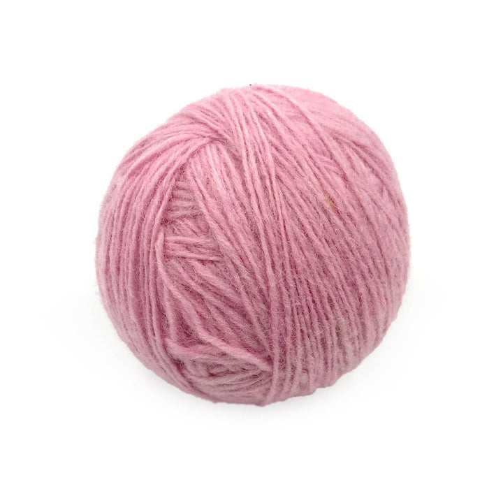 pink yarn cake over a white background