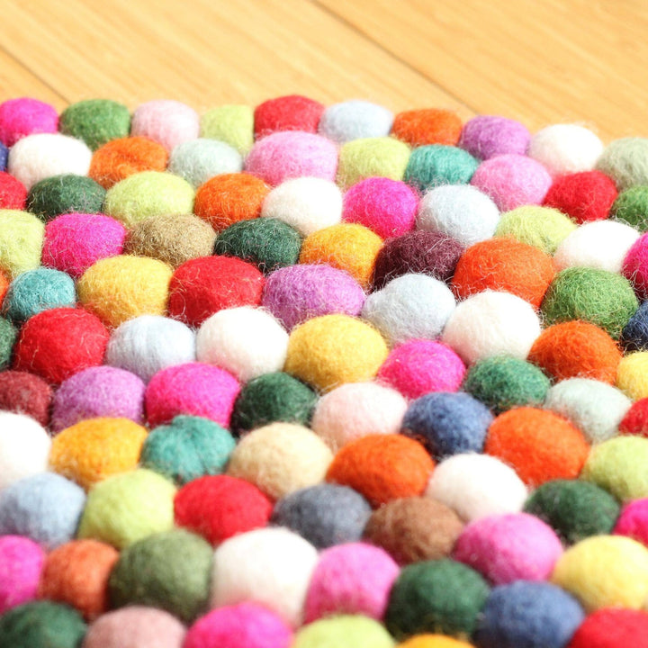 An up-close shot of multi-Color felt balls, forming a rug. Showing the texture.