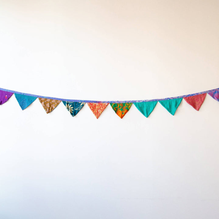 Handmade Recycled Sari Silk Bunting Banner hanging in a white wall