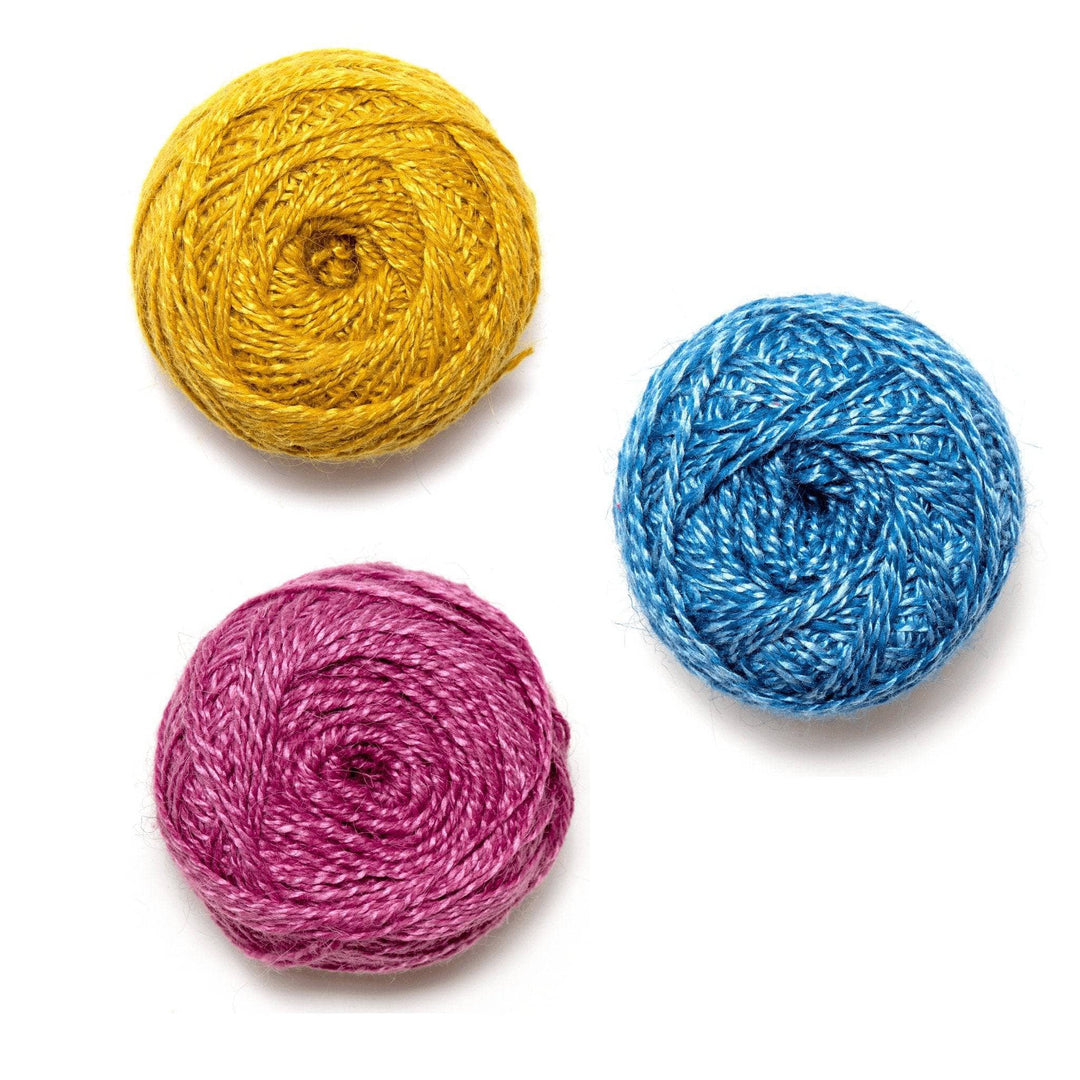 2 cakes of silky wool plied yarn in front of a white background. Top to bottom - marigold, indigo, and pink flower.