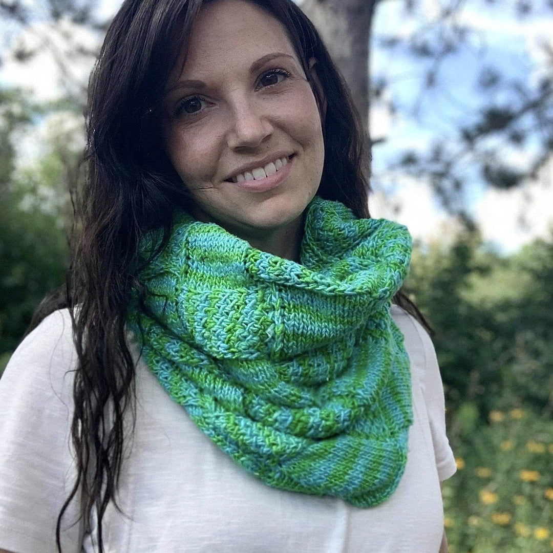 a person wearing a blue and green cowl outside