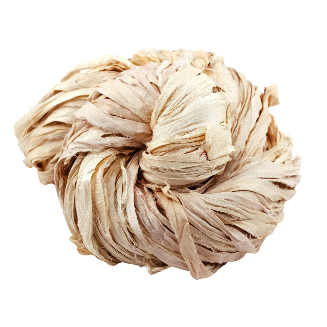 Single skein of sari silk ribbon yarn (off-white) in front of a white background. 