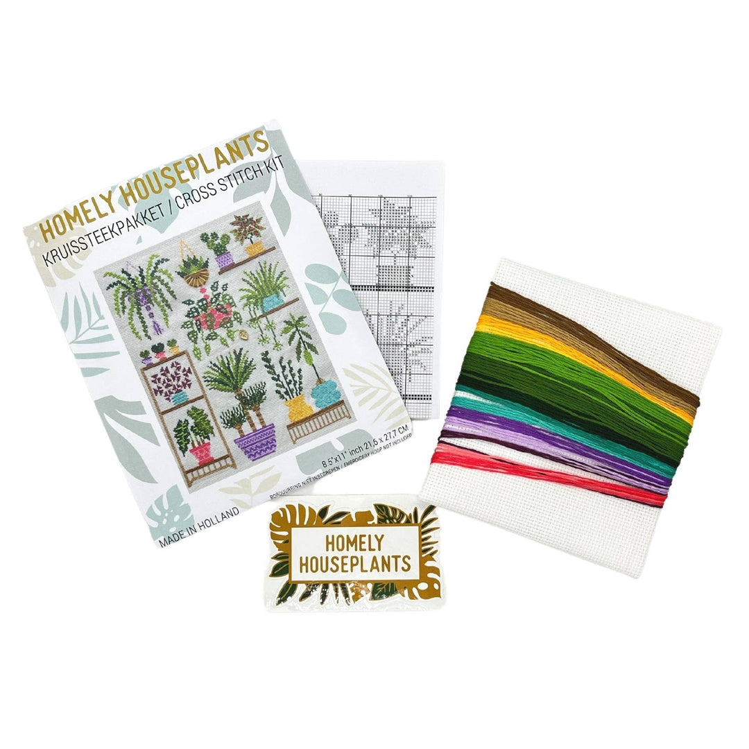 supplies for houseplant themed cross stitch kit in front of a white background. Includes fabric, multicolor DMC embroidery floss, chart, and sticker. 