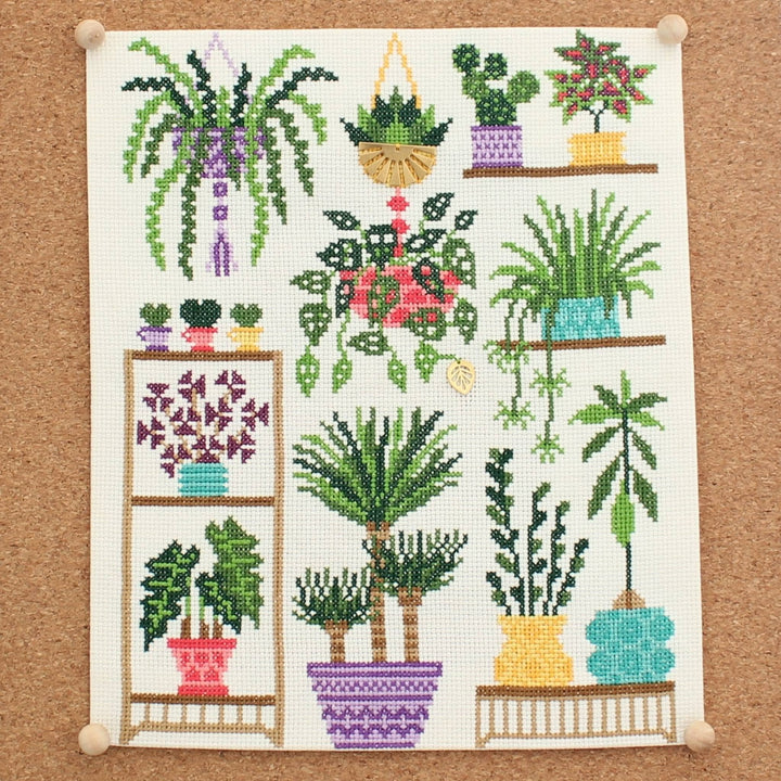 completed cross stitch kit featuring a myriad of potted and hanging green houseplants.