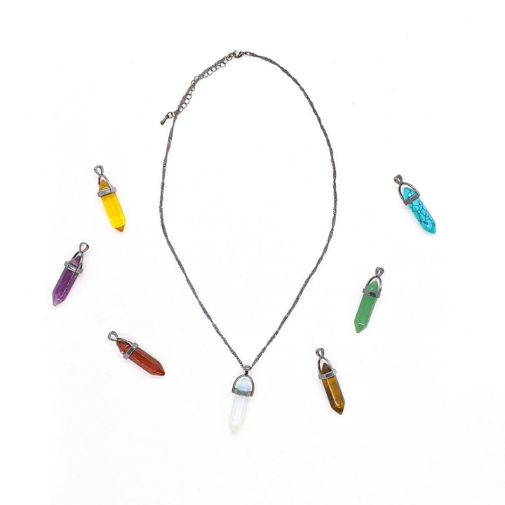 Chakra Necklace with 7 stones laid out around it on a white background.  