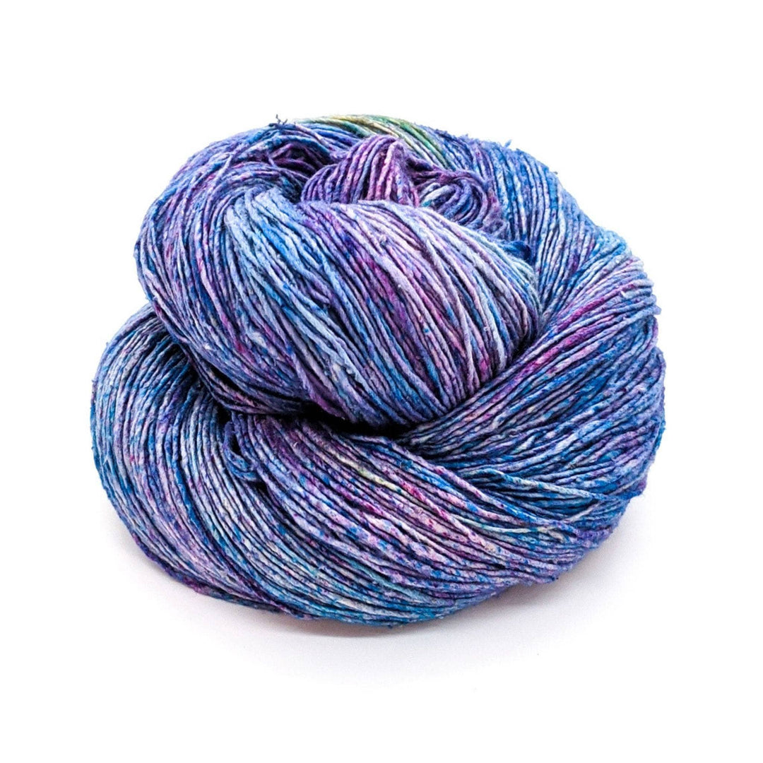 Single skein lace weight silk tidal pool (light blue and purple tonal with speckles) in front of a white background.