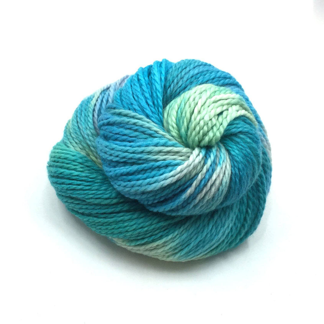 Aran twisted wool yarn in Jublio (teal and green) on a white background