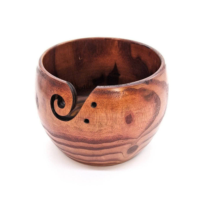 Wooden yarn bowl on a white backdrop. 