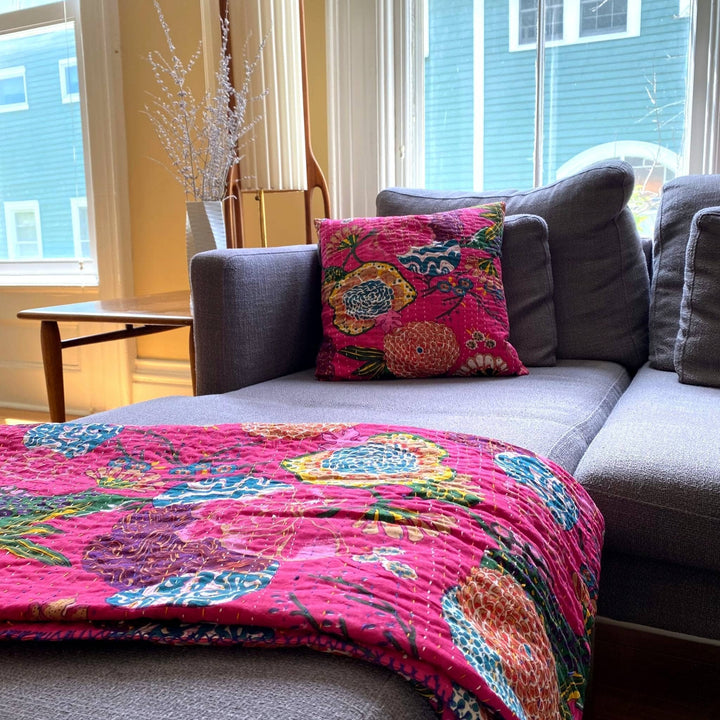 Tropical Oasis Kantha Quilt and Pillow Cover Set on a grey couch.  
