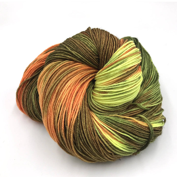 Superwash merino wool sock yarn ball in Amaia (brown, orange, yellow) on a white background