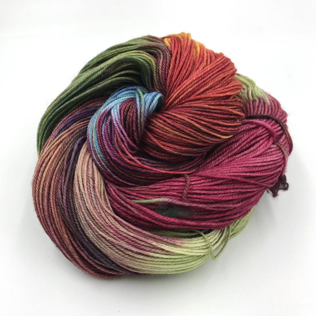 Superwash merino wool sock yarn ball in Bloom (multicolored) on a white background