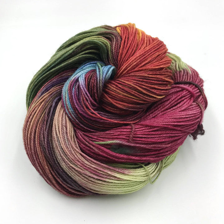 Superwash merino wool sock yarn ball in Bloom (multicolored) on a white background