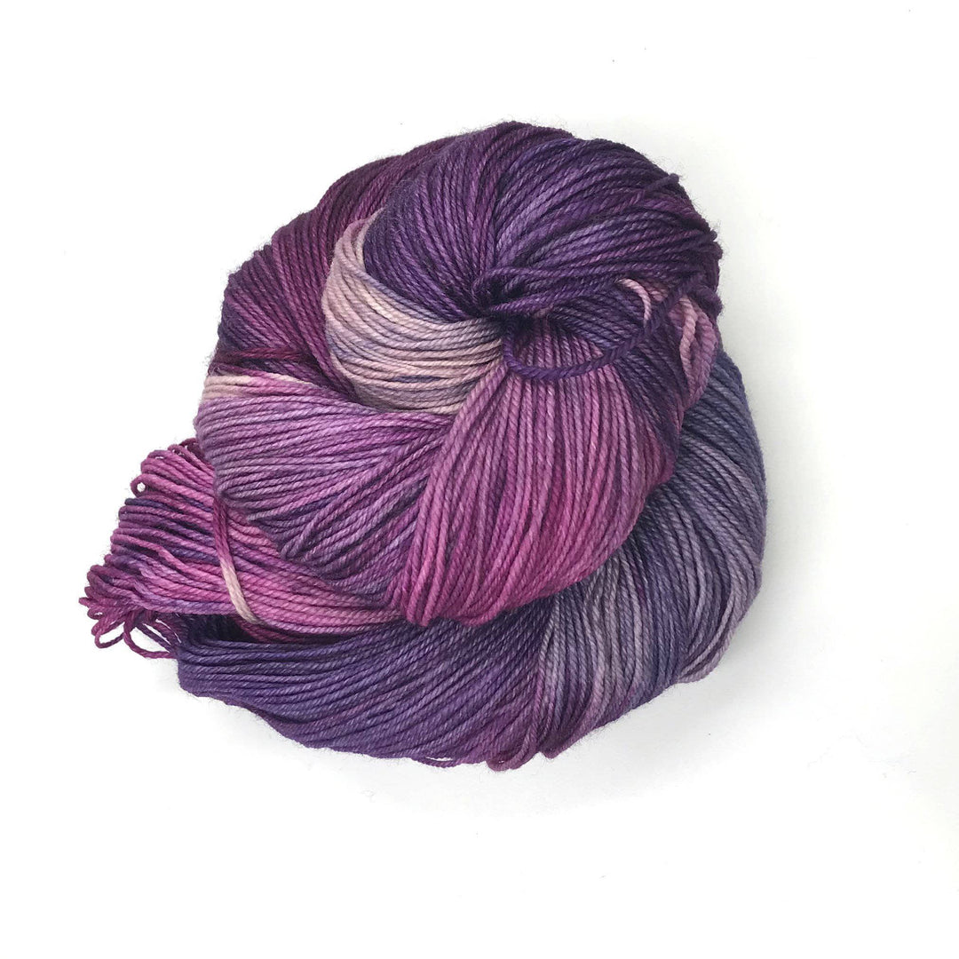 Superwash merino wool sock yarn ball in Dreams (pink, purple) on a white background