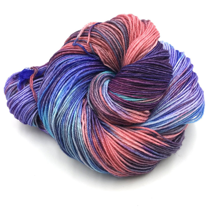 Superwash merino wool sock yarn ball in Harmonious (blue, purple, pink) on a white background