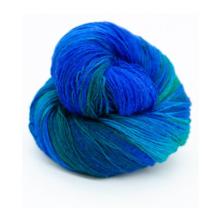 Blue and green variegated lace weight yarn in front of a white background. 