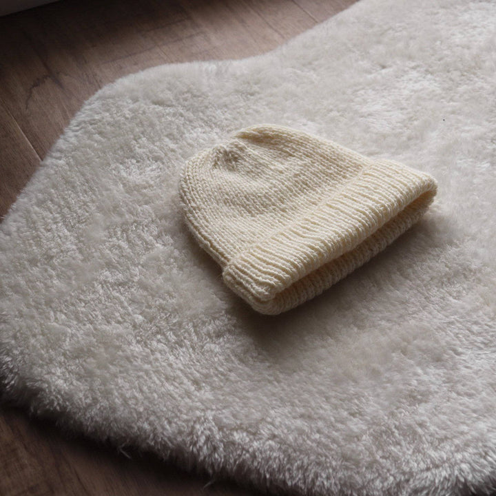 White knit hat on a white white carpet