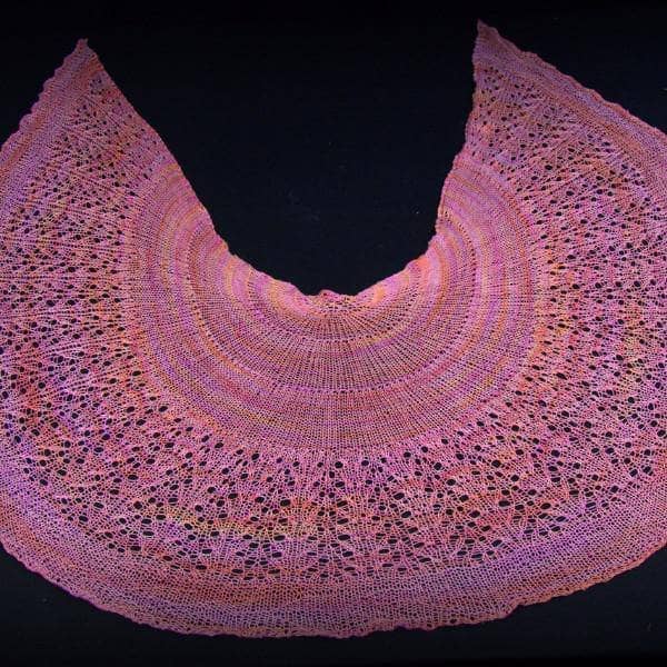 close up of a pink shawl with a black background