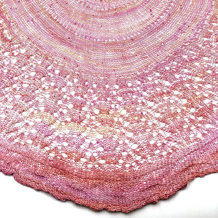close up of a pink shawl with a white background
