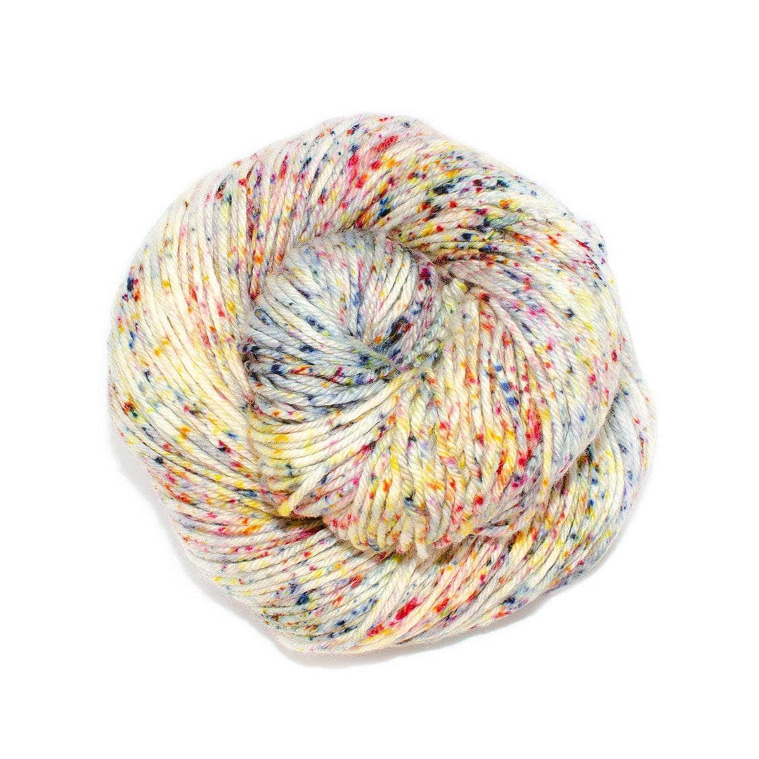 A skein of variegated white with specked yarn on a white background