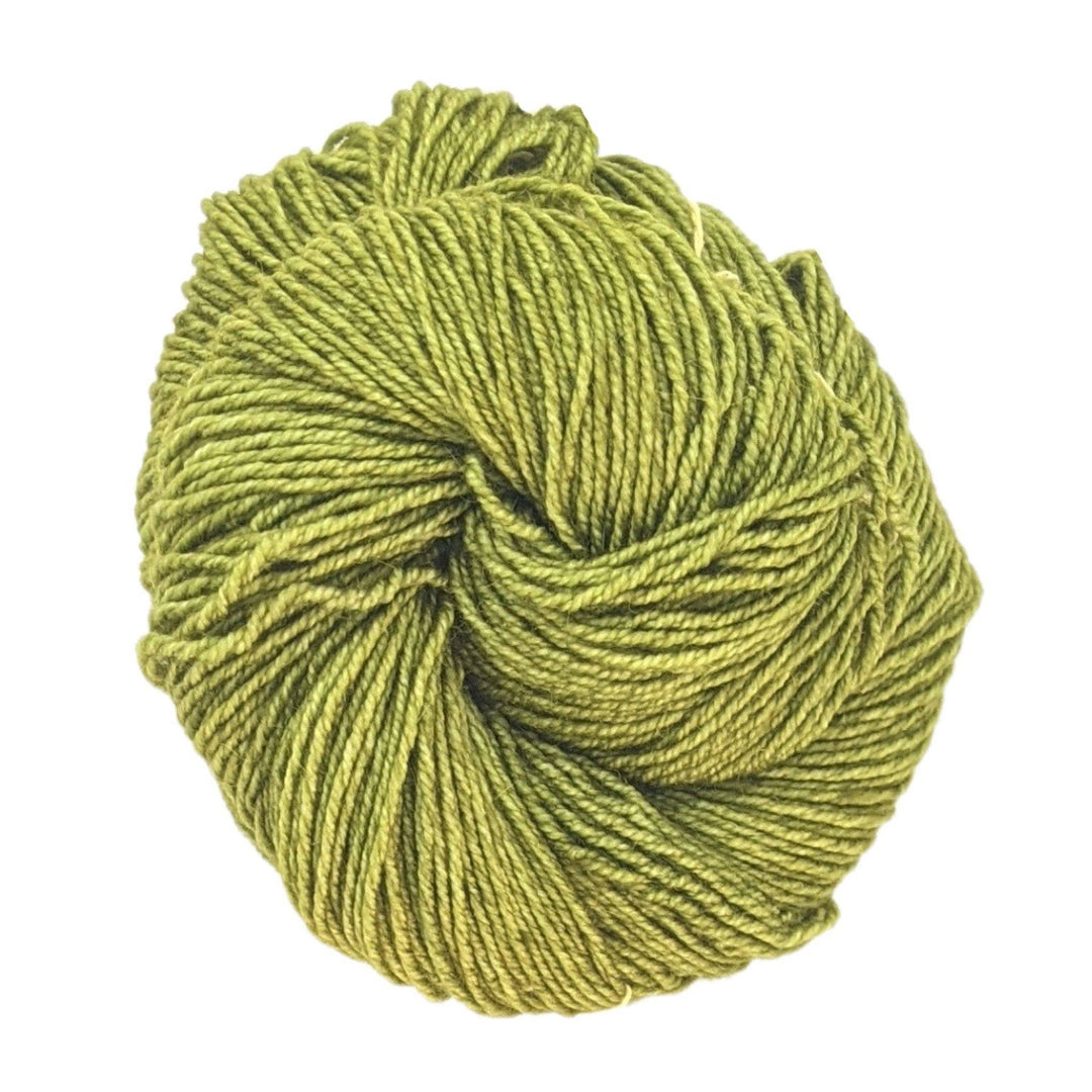 skein of tonal green yarn in front of a white background.
