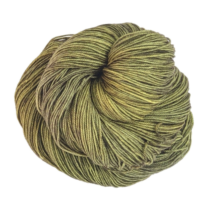 skein of tonal green yarn in front of a white background.