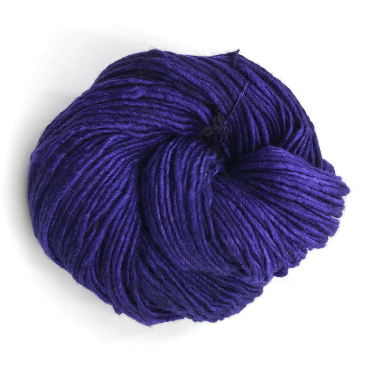 skein of dark purple yarn in front of a white background.