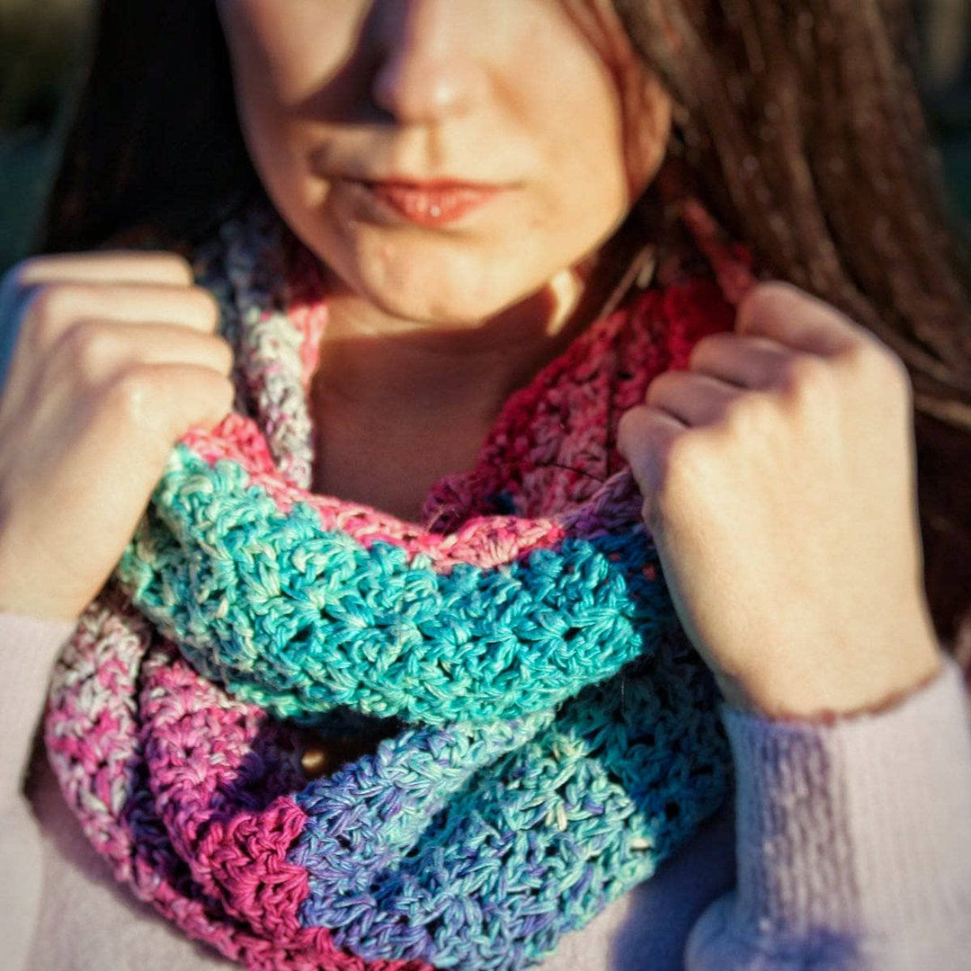 woman holding a colorful crochet scarf