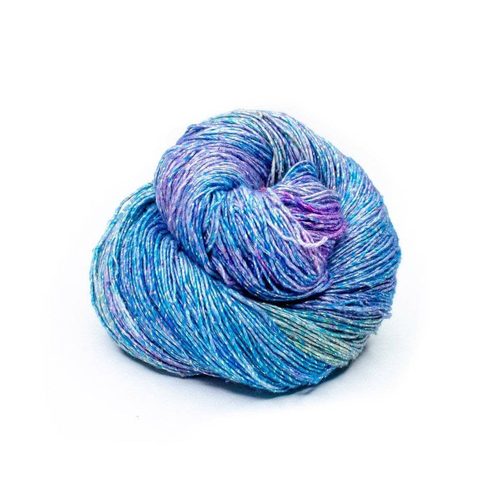 a skein of blue and purple sparkle yarn on a white background 