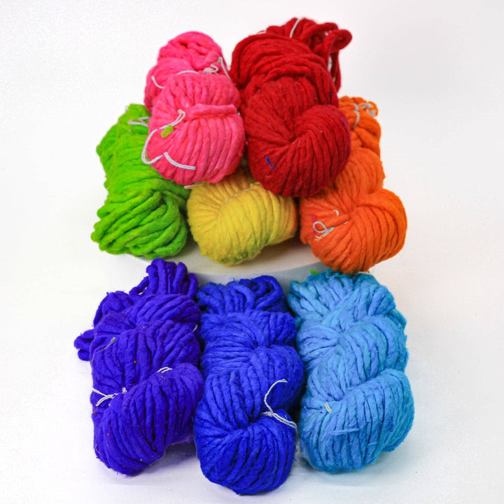 8 skeins super bulky recycled silk rainbow dyed yarn pack in front of a white background.