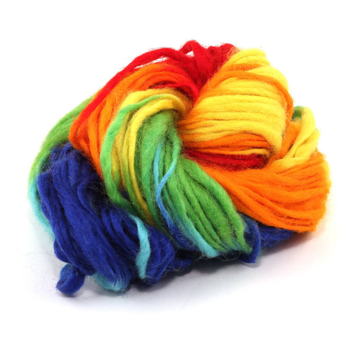 cake of yarn in the color technicolor dreams (rainbow colors) with a white background