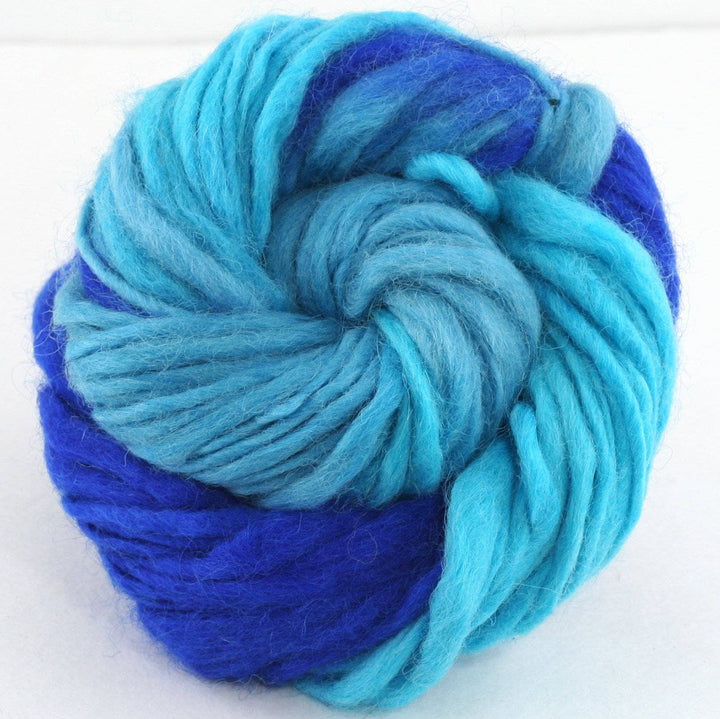 cake of yarn in the color waves (teal and blue) with a white background