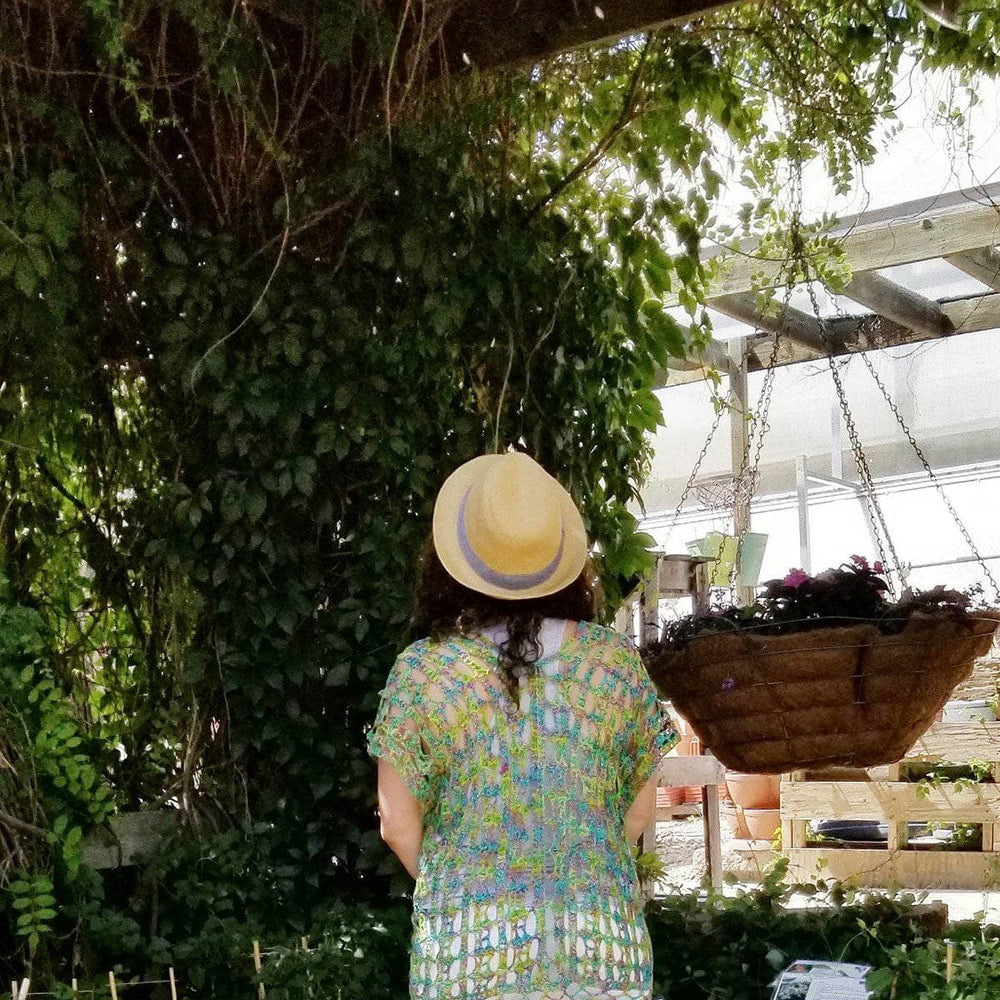 woman wearing a green poncho looking at tree 
