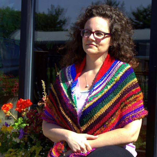 front of a woman wearing colorful red yellow blue and brown shawl