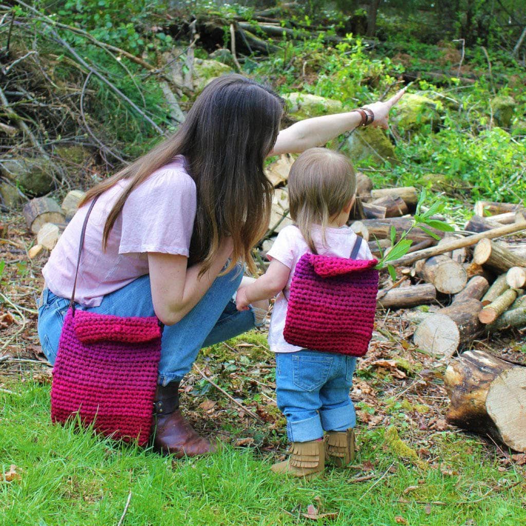 mom and child wearing a pink bag in a garden