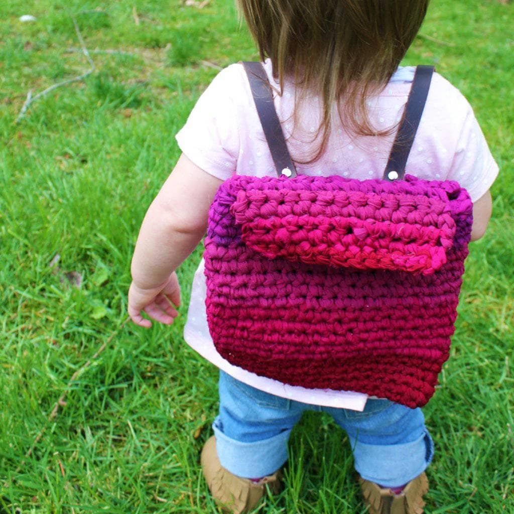 child with a purple bag